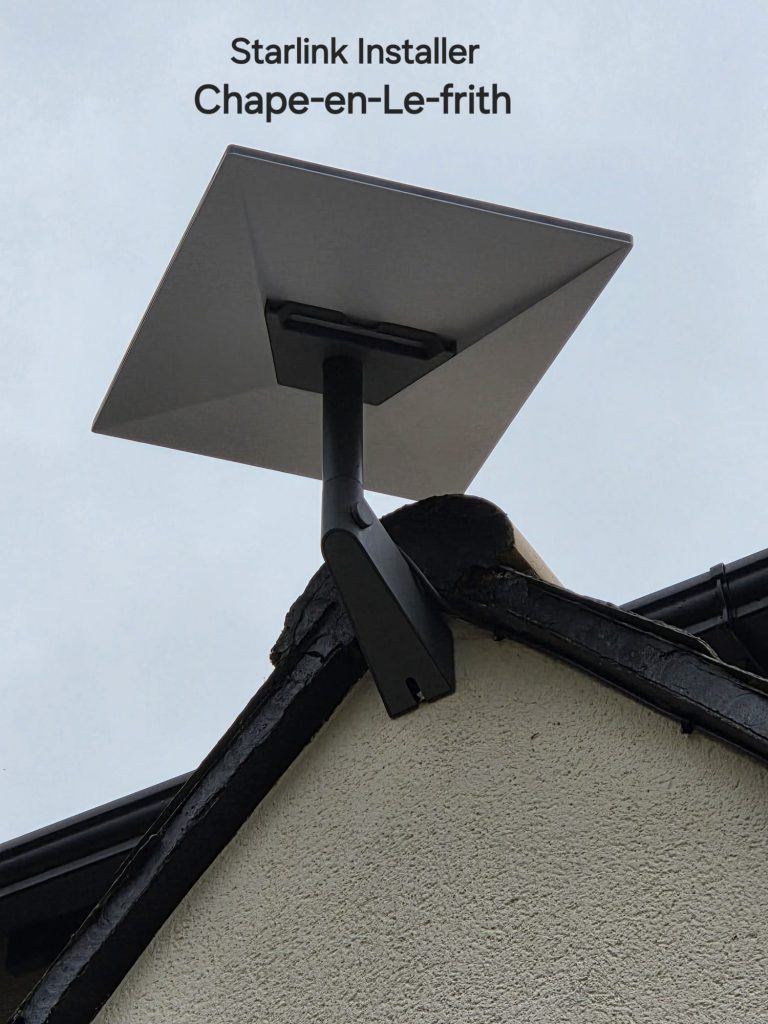 Starlink dish on an angled mount near the apex of a rendered gable in Chapel-en-le-Frith