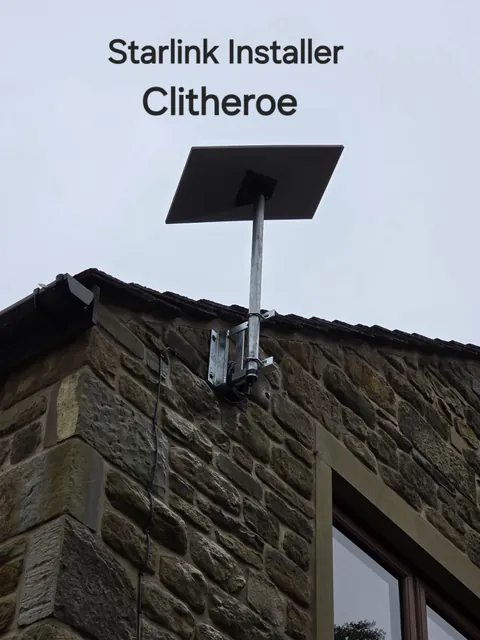 Starlink dish on a metal pole with twin brackets fixed to a stone wall in Clitheroe